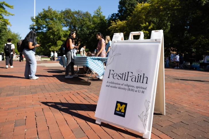 People tabling on the Diag in front of a sign that says FestiFaith