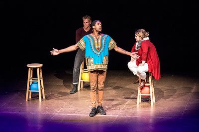 A person speaking on a stage while wearing a dashiki