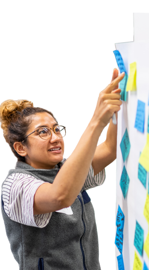 A person putting post-it notes on a wall