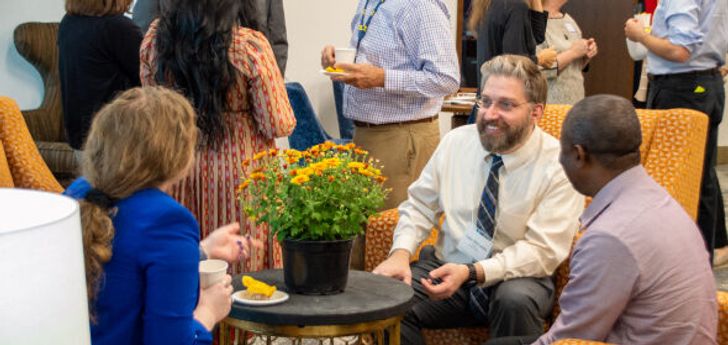 People sitting in armchairs and having a conversation at an event