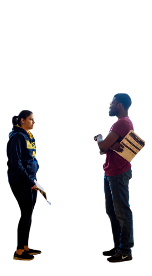 Two people holding papers and having a conversation