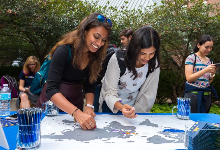 People marking a map on a table at an outdoor event