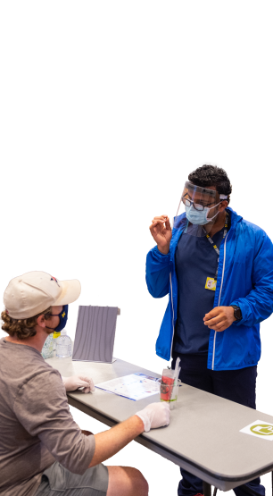 Two people having a conversation while wearing masks and other protective gear