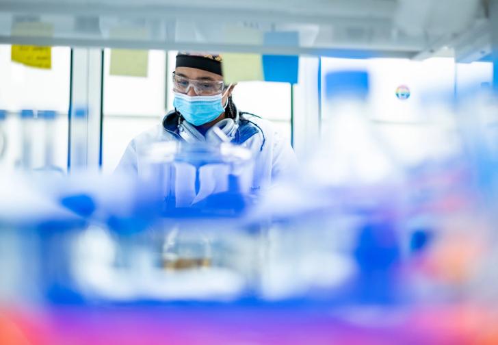 A person wearing safety gear while working in a lab