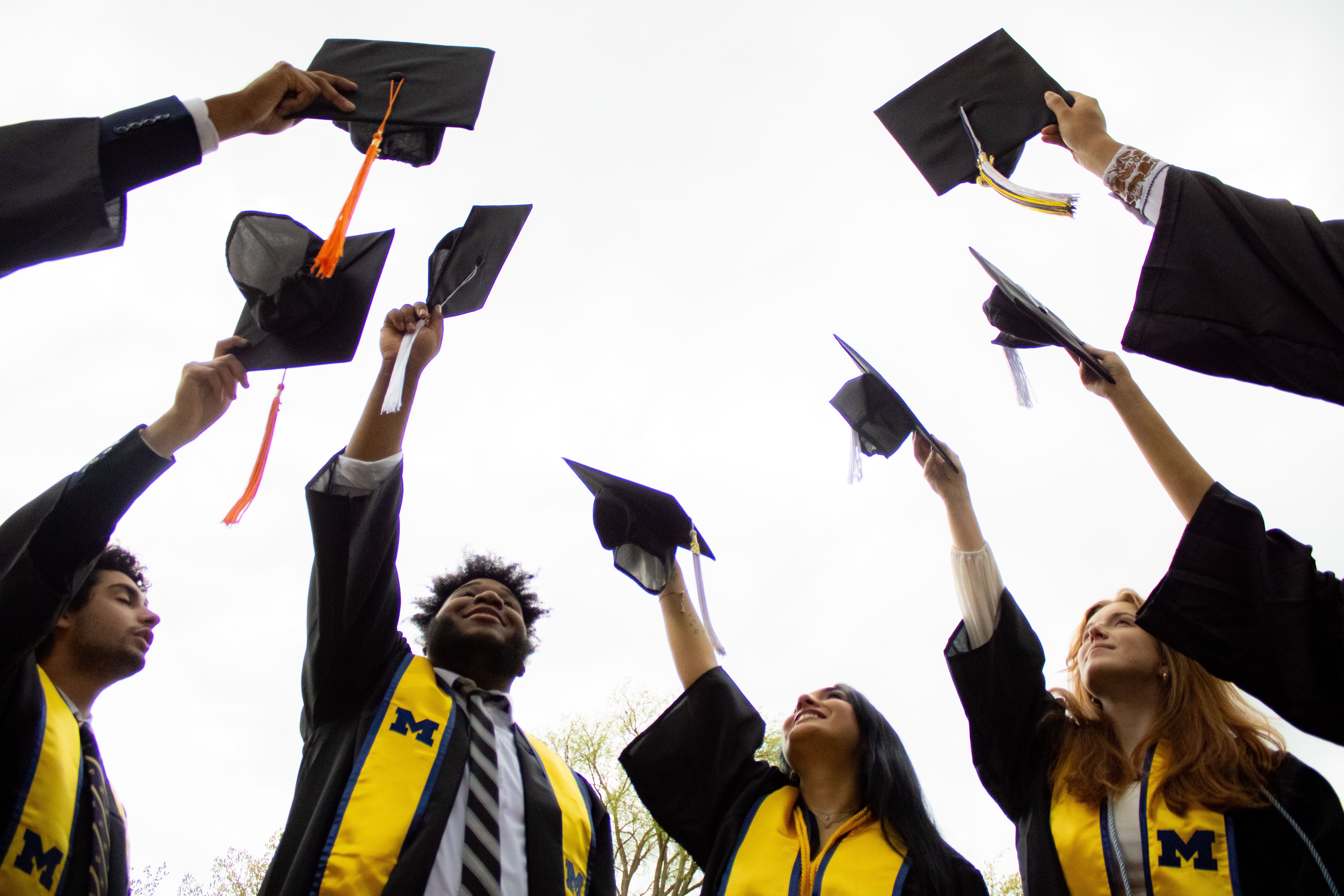 Graduates holding their caps in the air