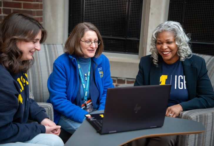 Staff members looking at a laptop together