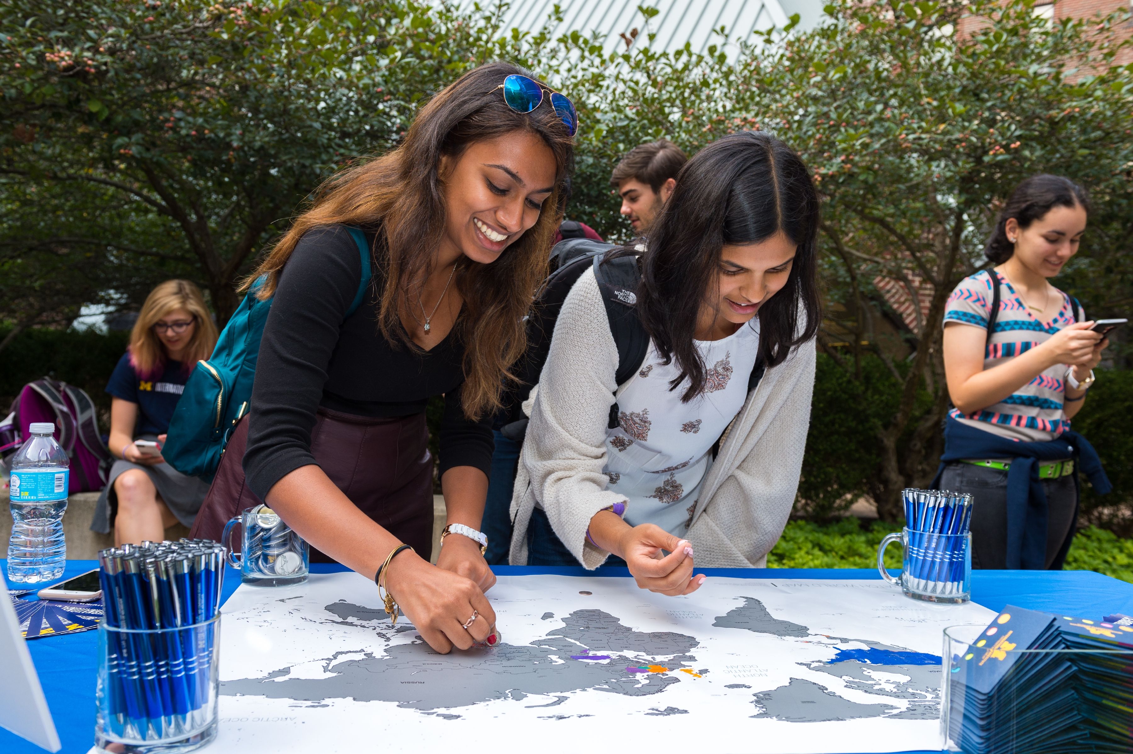 People marking a map on a table at an outdoor event